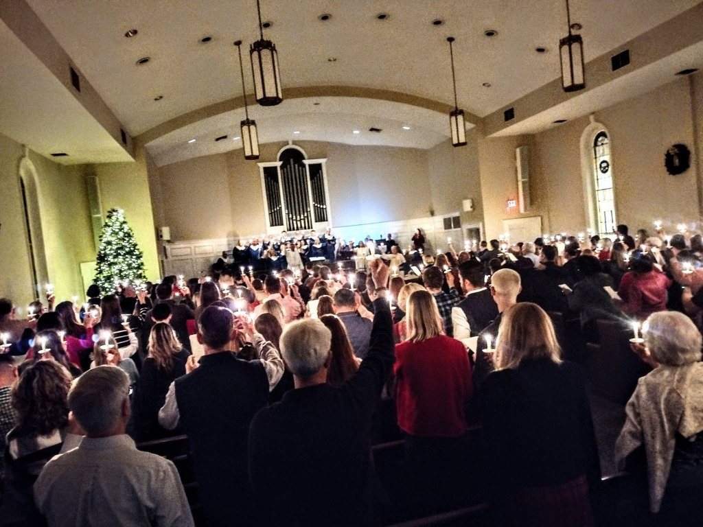 The sanctuary filled with candlelight as the choir sings on Christmas Eve