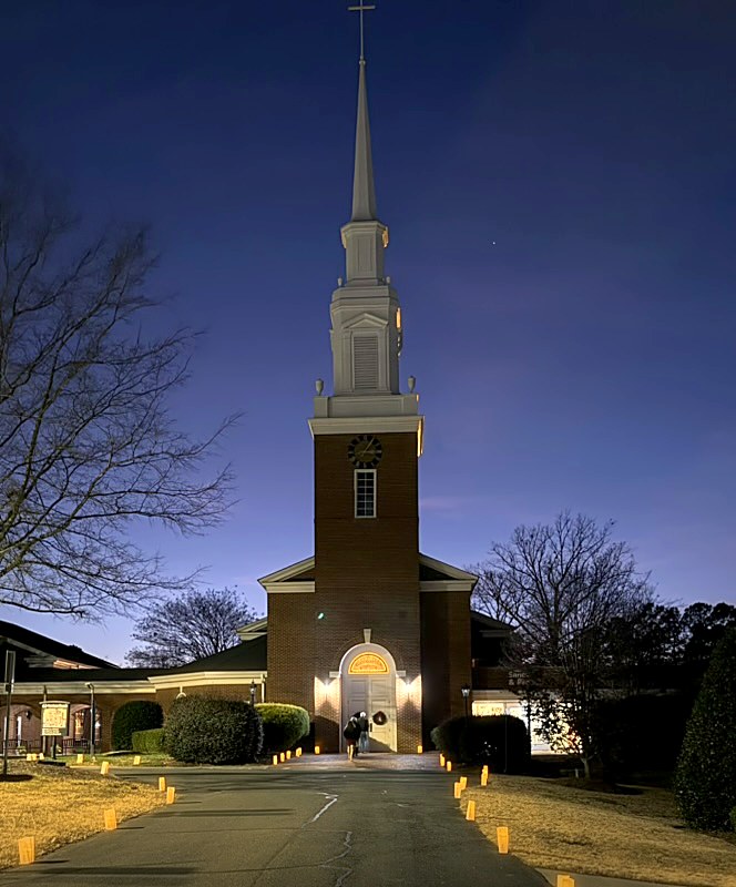 Luminaries lining the walkway to Harrison’s steeple at dusk on Christmas Eve