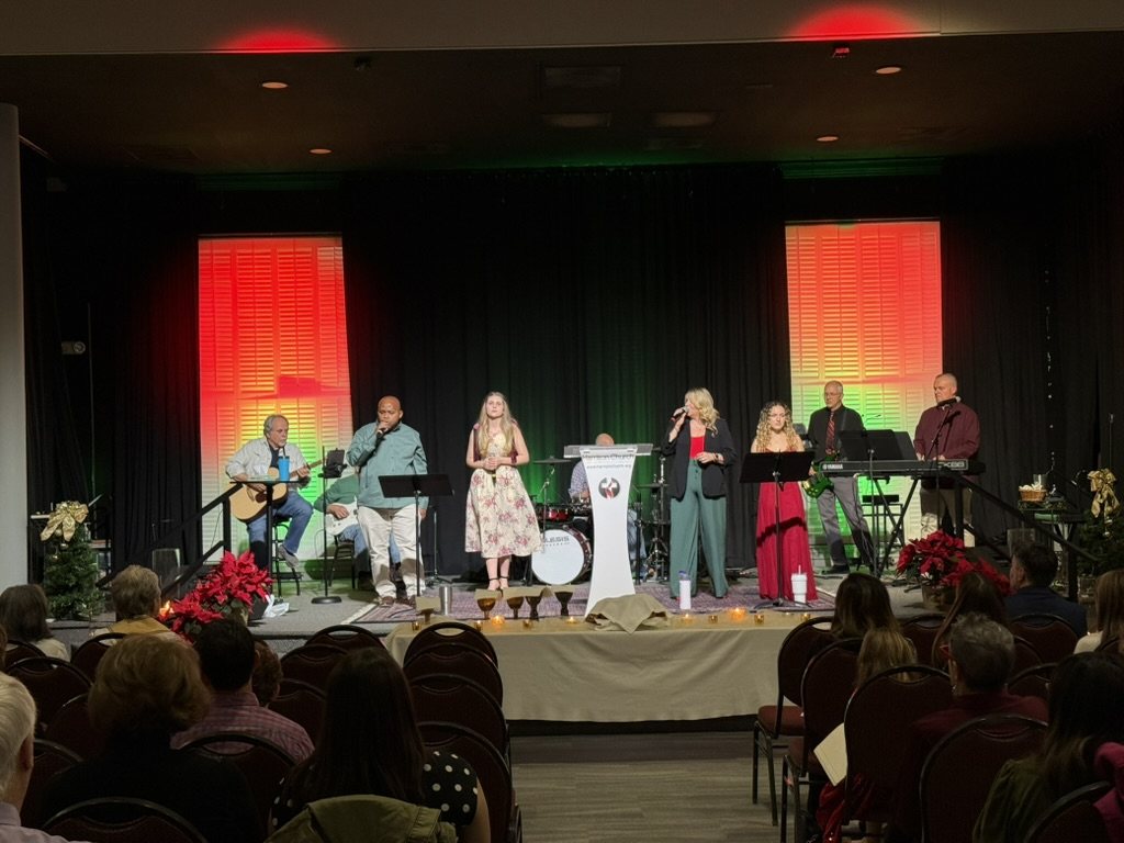 The praise band leading Christmas worship in Hammill Hall with poinsettias on stage